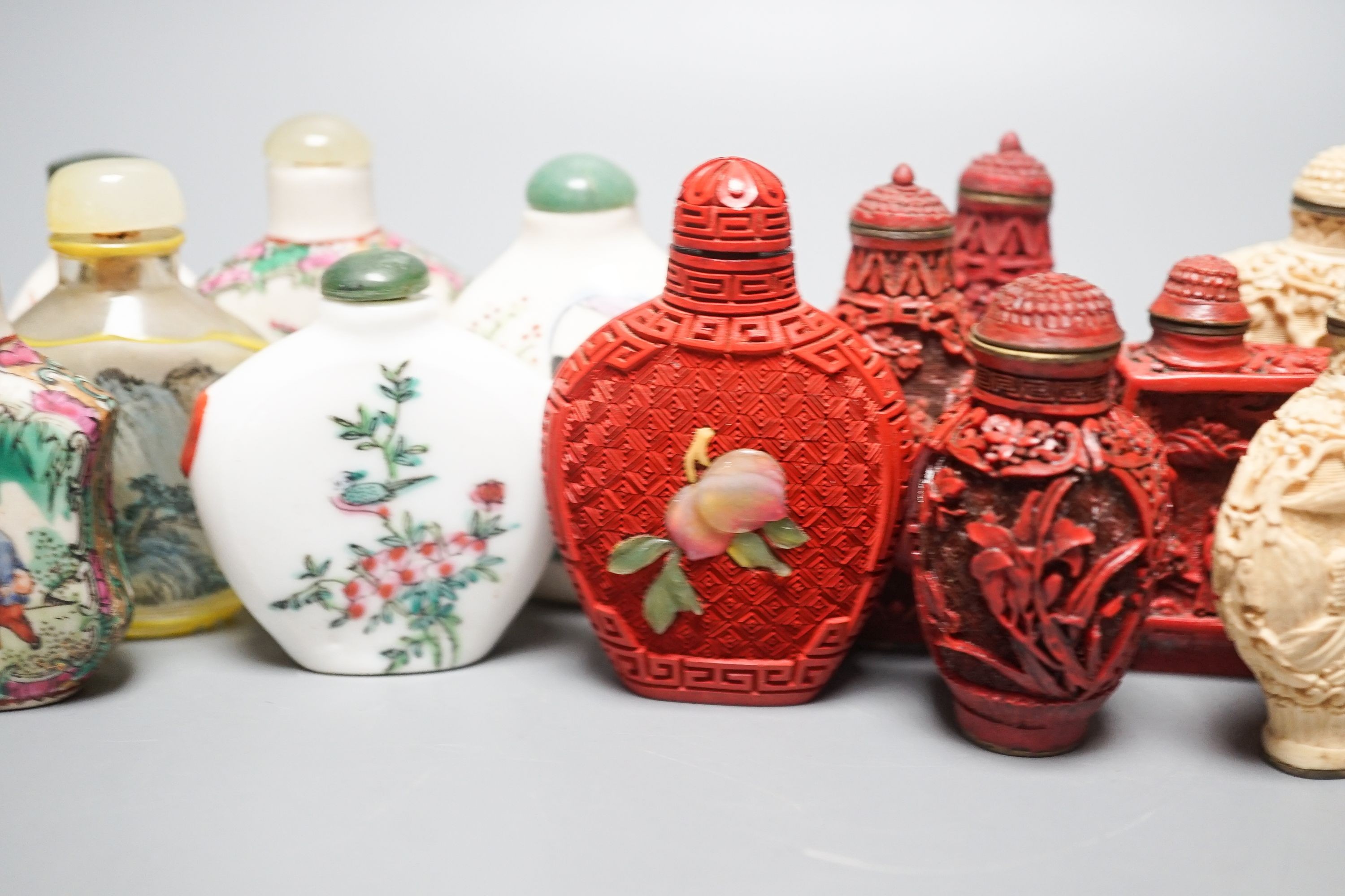 A collection of Chinese snuff bottles, 20th century, including a carved cinnabar lacquer and hardstone inlaid snuff bottle, 7.4cm (23)